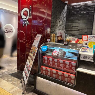 名古屋うまいもん通りにある、まるや本店の店頭。赤いパネルが目印で、持ち帰り用のひつまぶしが並んでいる。