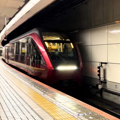 深い赤色の車体が特徴的な近鉄特急ひのとりがホームに停車している。