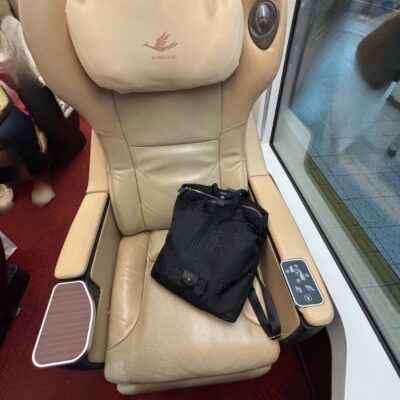 近鉄特急ひのとりのプレミアムシート。ゆったりした本革シートの上に黒いバッグが置かれている。