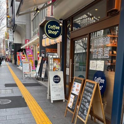 Coffee Shop 伏見本店の外観。青い看板と木製のメニュー看板が並ぶ、落ち着いた雰囲気のコーヒー専門店。