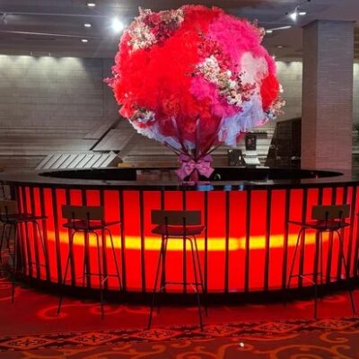 名古屋観光ホテルのロビーにある、赤とピンクの大きなフラワーアレンジメント。下から照らす赤いライトが華やかさを演出している。