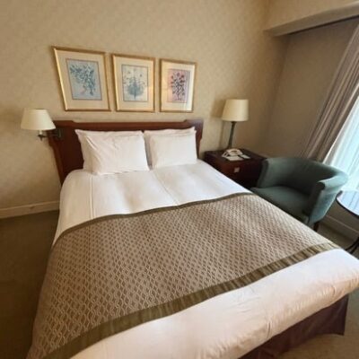 名古屋観光ホテルの客室。広いベッドと落ち着いたインテリアの部屋