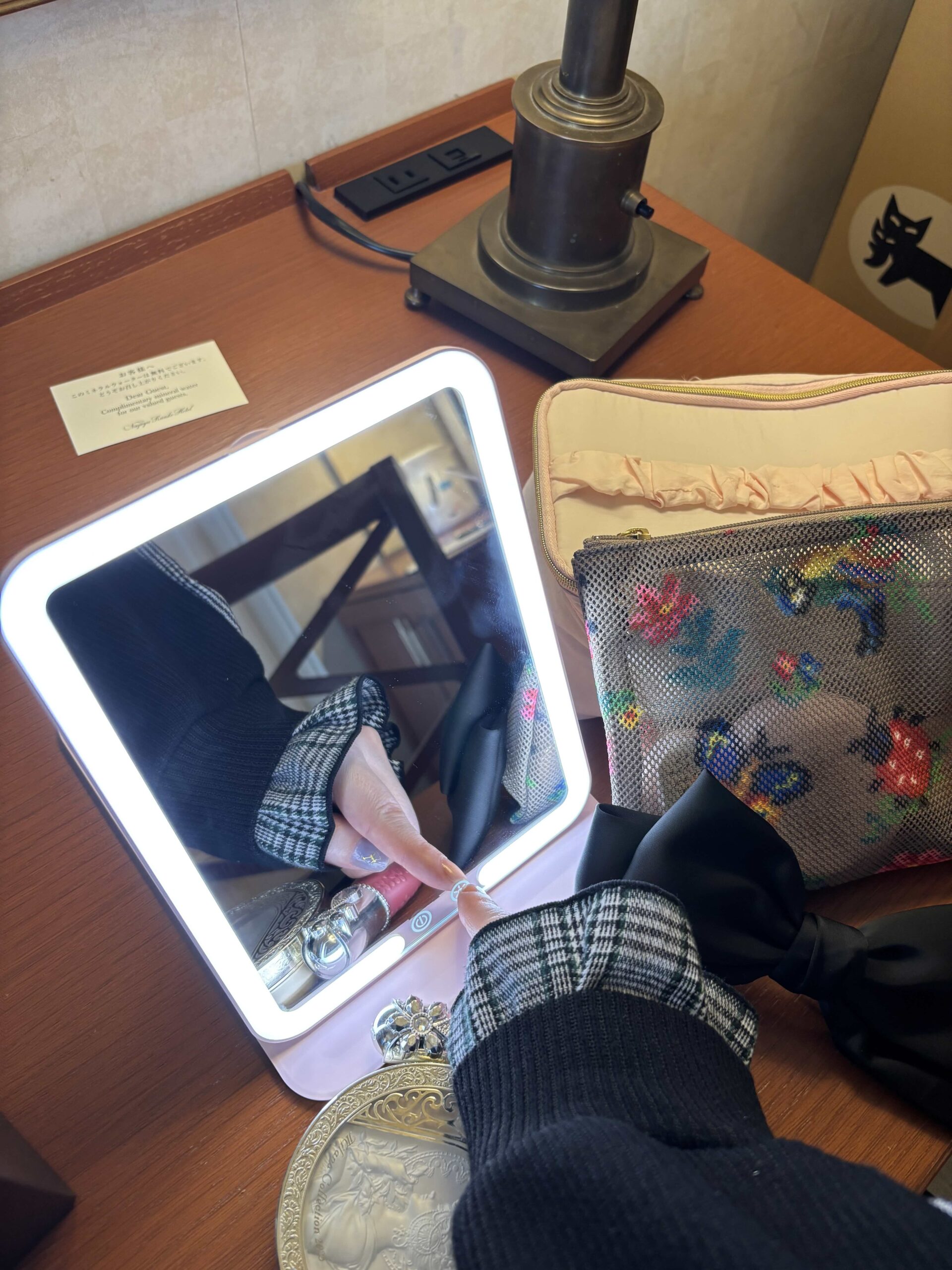 ホテルの部屋でLEDライト付きメイクミラーを使っている様子