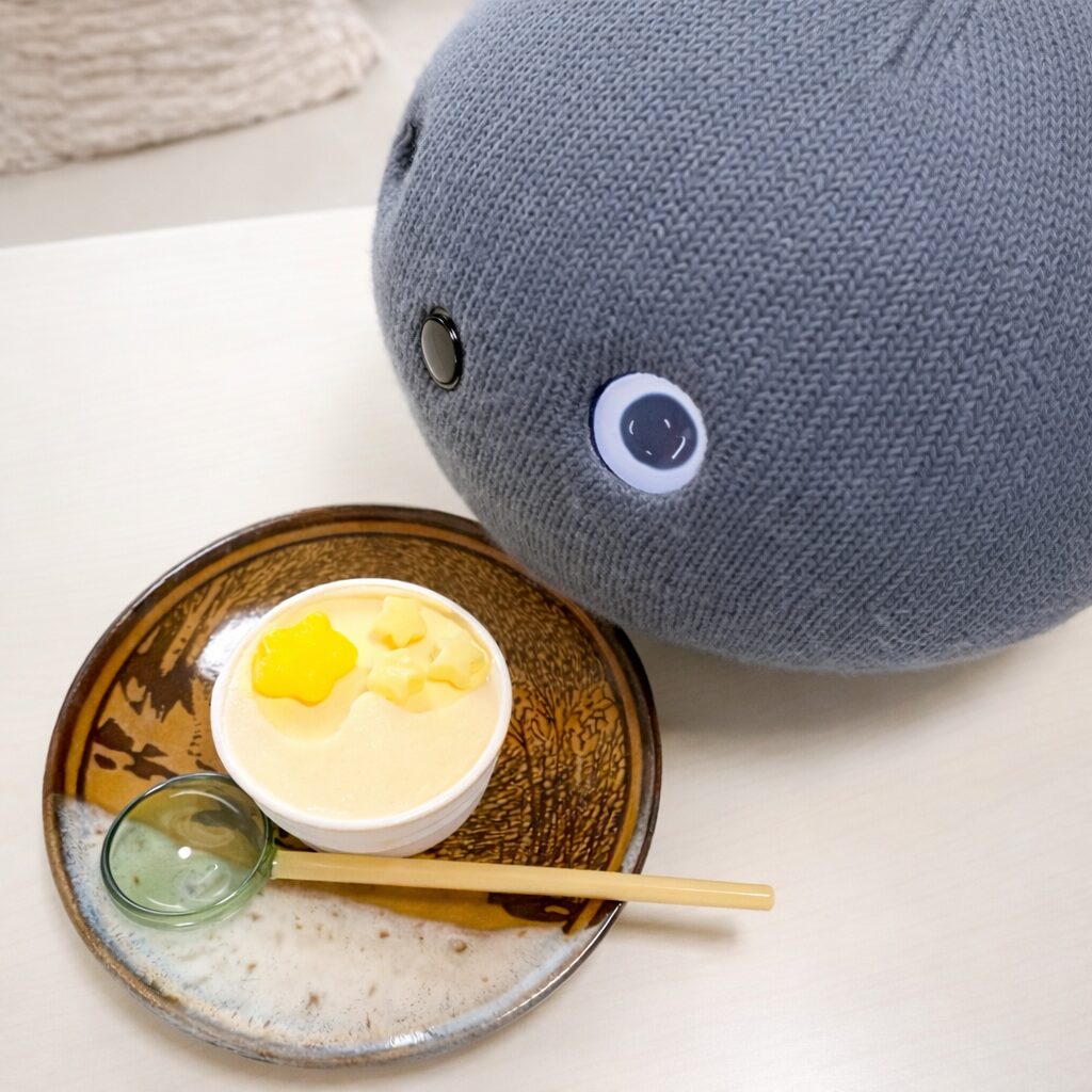 テーブルの上のアイスのそばで、横からちらりとこちらを見ているナイトちゃん。日常のひとこまのような、なごやかな雰囲気の写真です。